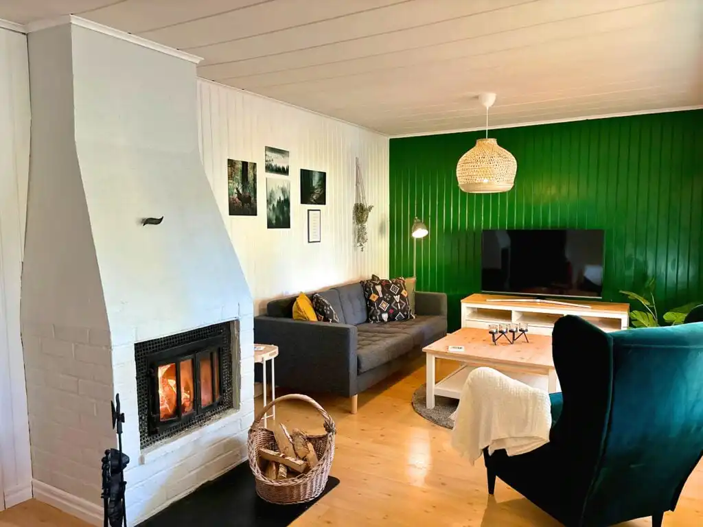 Wohnzimmer mit Kamin in der Villa Lotte – gemütliches Ferienhaus am See in Småland