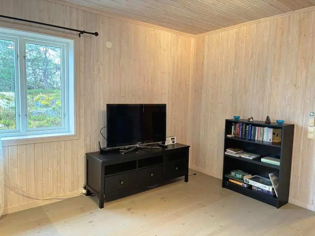 Wohnzimmer mit TV im Ferienhaus Hus Kråkelund – entspannter Wohnbereich im Schwedenhaus