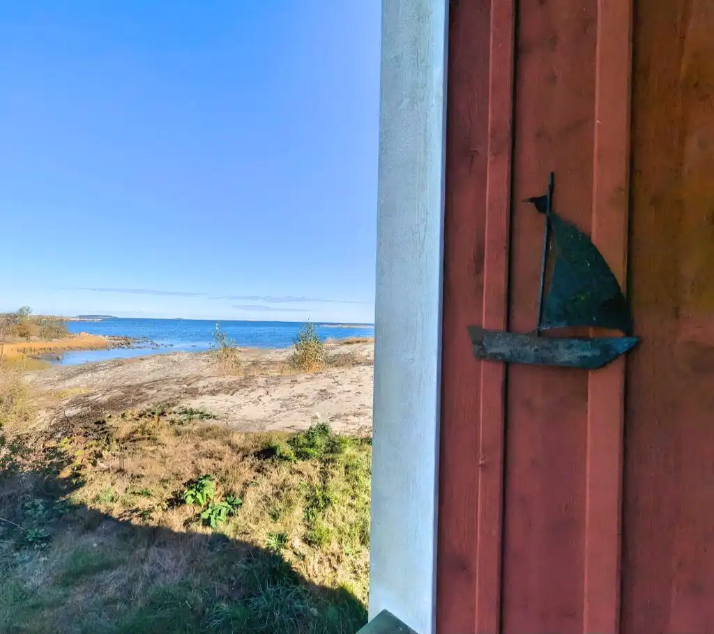 Detailaufnahme der roten Holzfassade des Ferienhauses Hus Kråkelund
