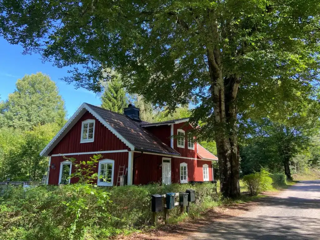 Ferienhaus Torsholma Skolhus zwischen Bäumen in Småland – traditionelles rotes Schwedenhaus in ruhiger Waldlage