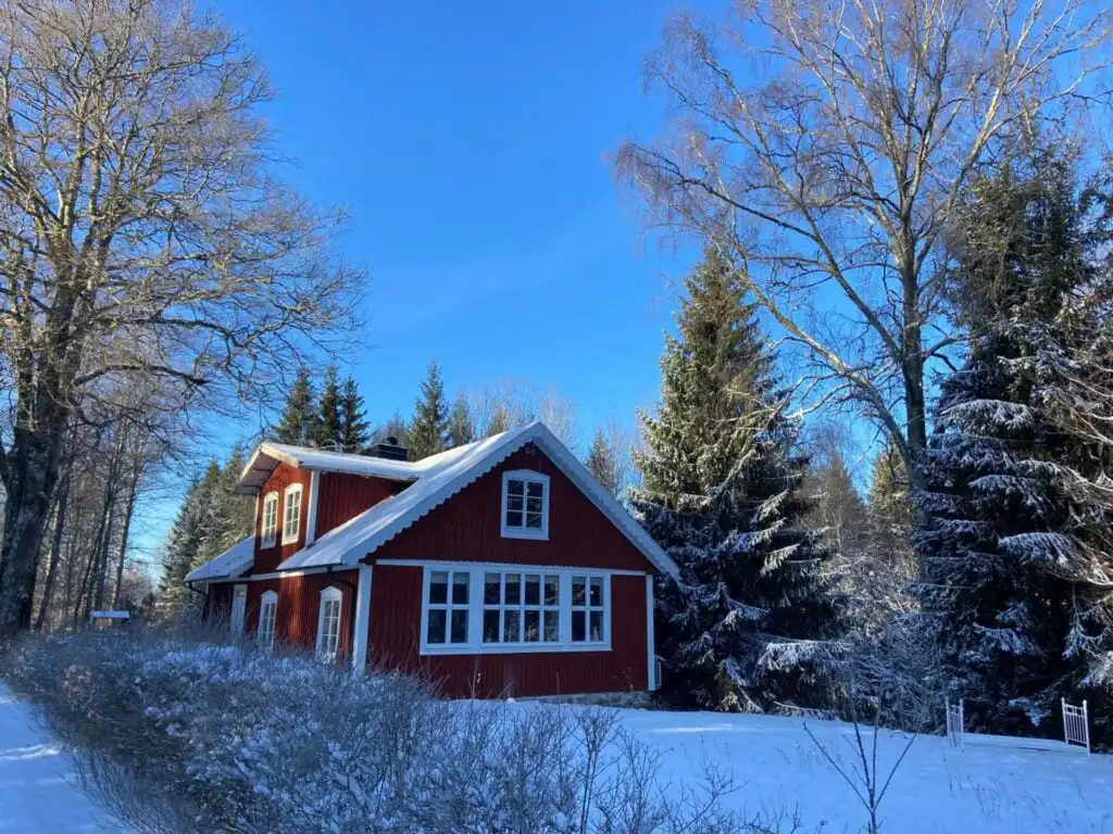 Rotes Ferienhaus Torsholma Skolhus in winterlicher Landschaft in Småland – historisches Schulhaus für ruhigen Schwedenur