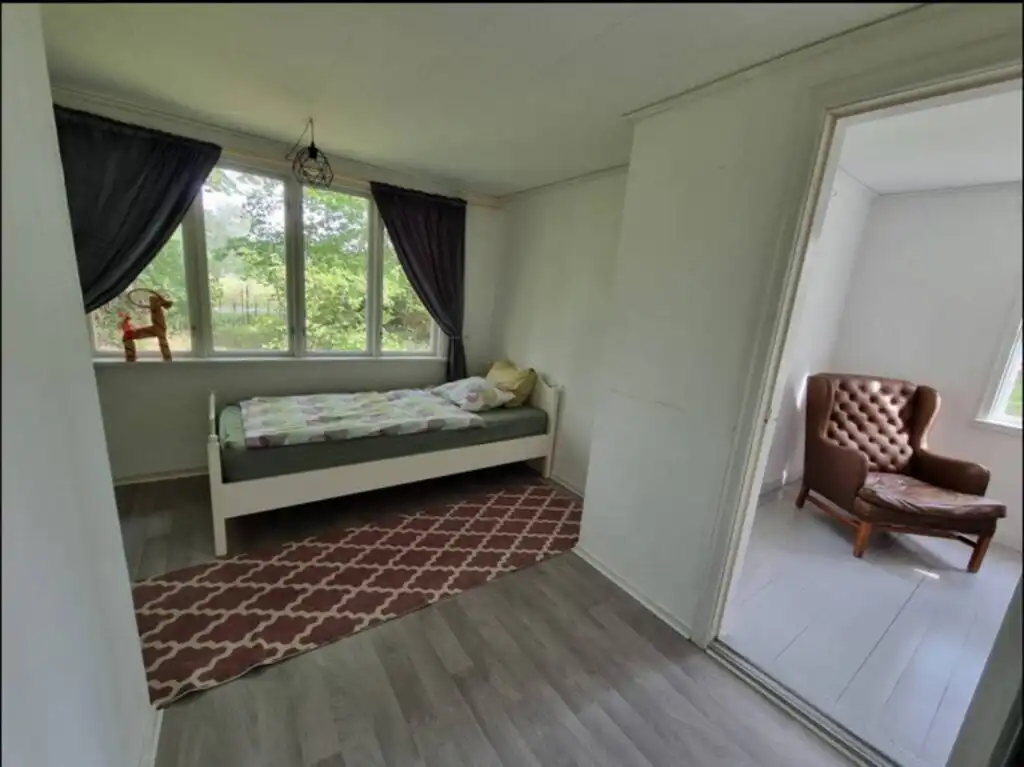 Schlafzimmer mit Fensterblick im Ferienhaus Hus Blommenshöns bei Ruda – Natururlaub in Småland