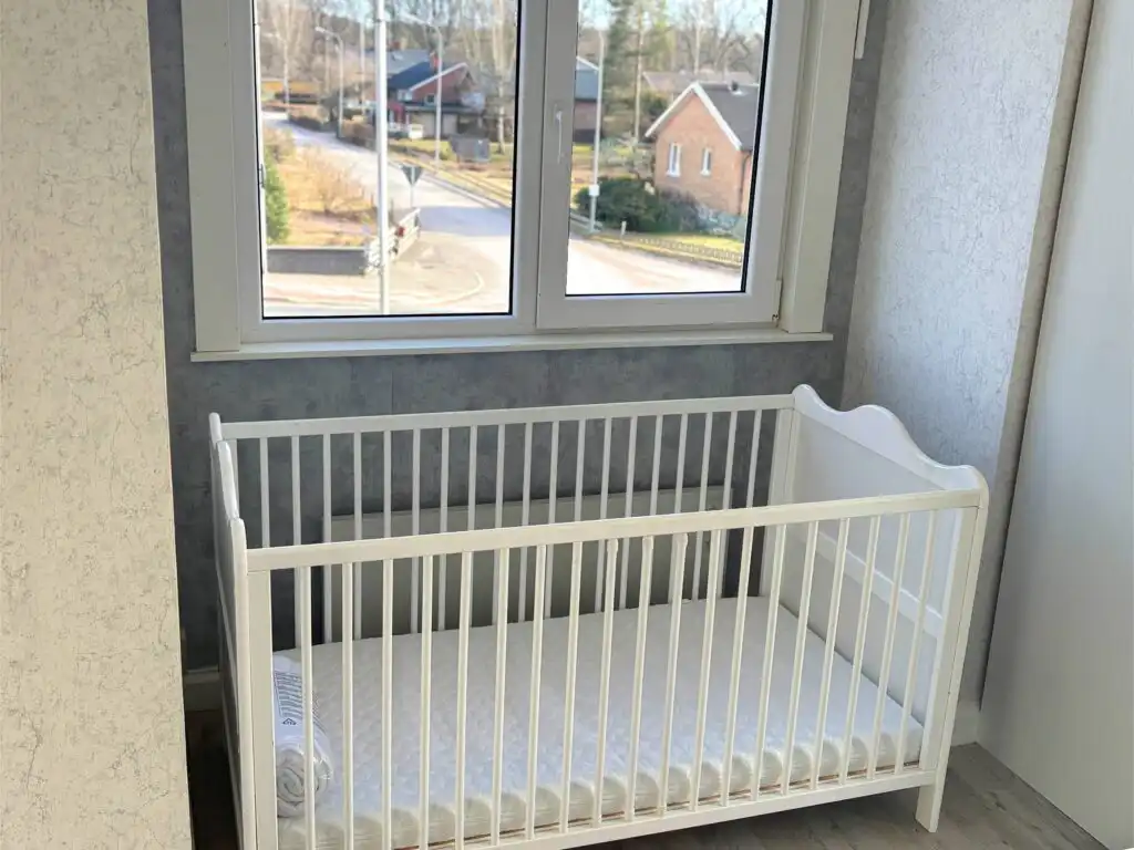 Schlafzimmer mit Babybett im Ferienhaus beim Michel in Järnforsen – familienfreundliches Ferienhaus in Småland