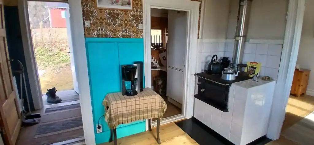 Wohnzimmer mit Kamin im Ferienhaus Hus Hammarstrand – gemütlicher Wohnbereich im traditionellen Schwedenhaus
