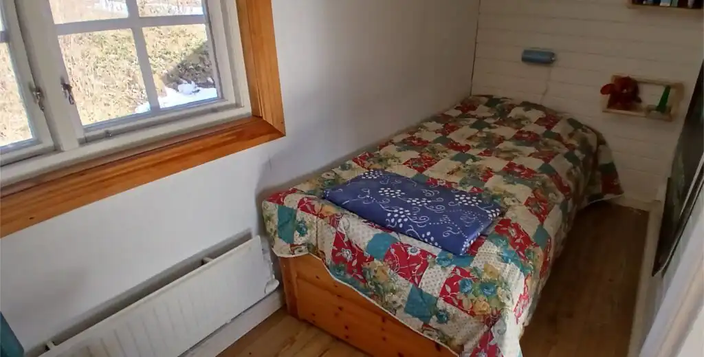 Schlafzimmer mit Einzelbett im Ferienhaus Hus Hammarstrand – schlichtes Zimmer im traditionellen Schwedenhaus