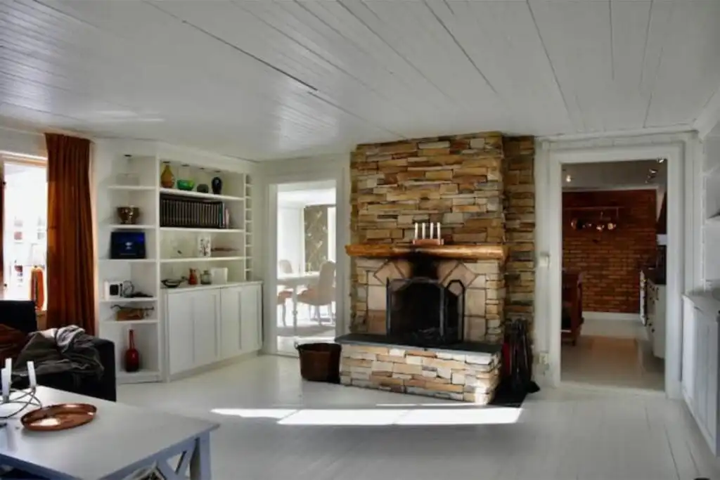 Wohnzimmer mit Kamin im Ferienhaus Kopperhemmets Gård in Gällstad