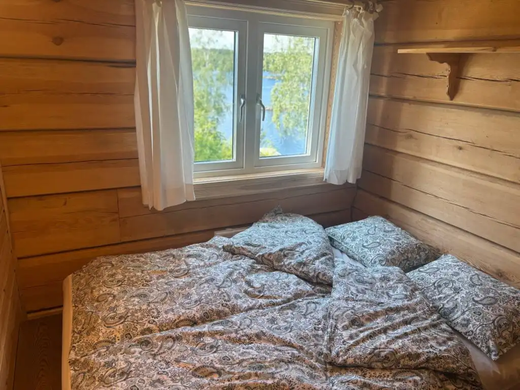 Schlafzimmer mit Holzwänden in der Blockhütte Ratzeputz in Skillingfors – gemütliche Jagdhütte