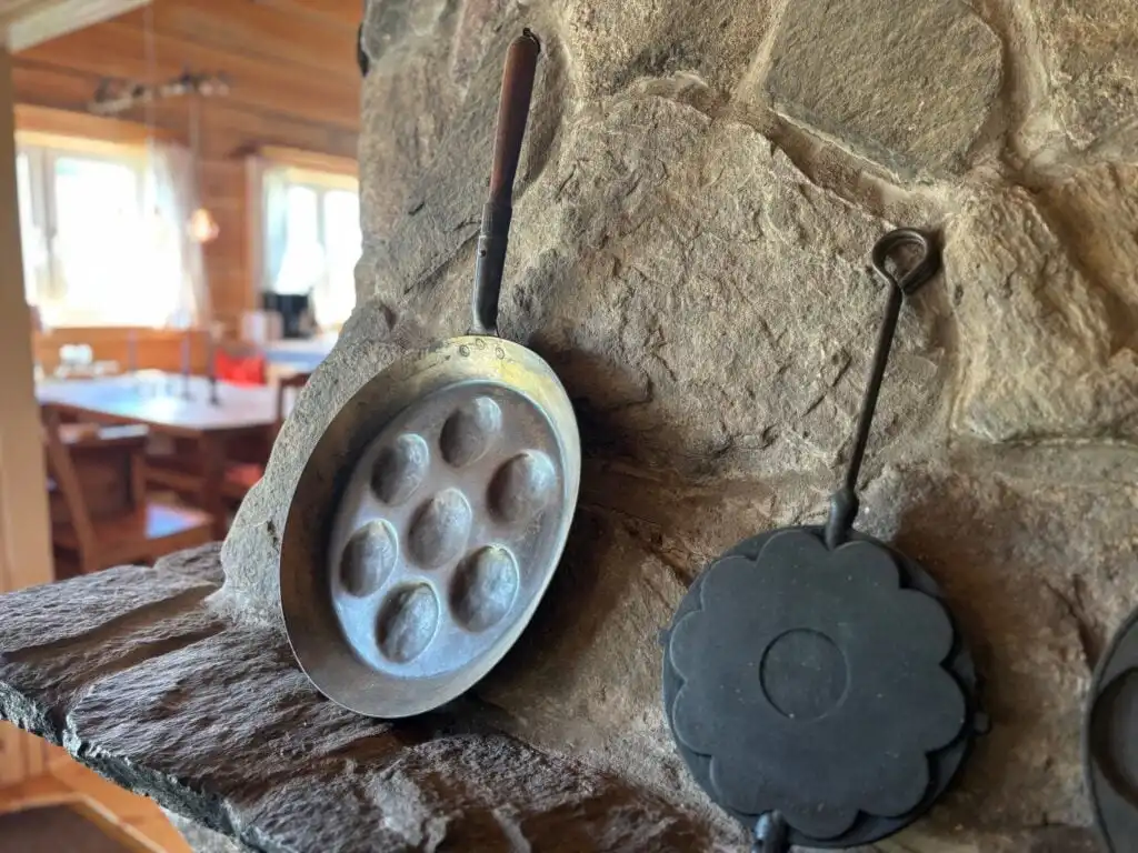 Wohnbereich mit Natursteinwand in der Blockhütte Ratzeputz in Skillingfors – urige Jagdhütte in Värmland