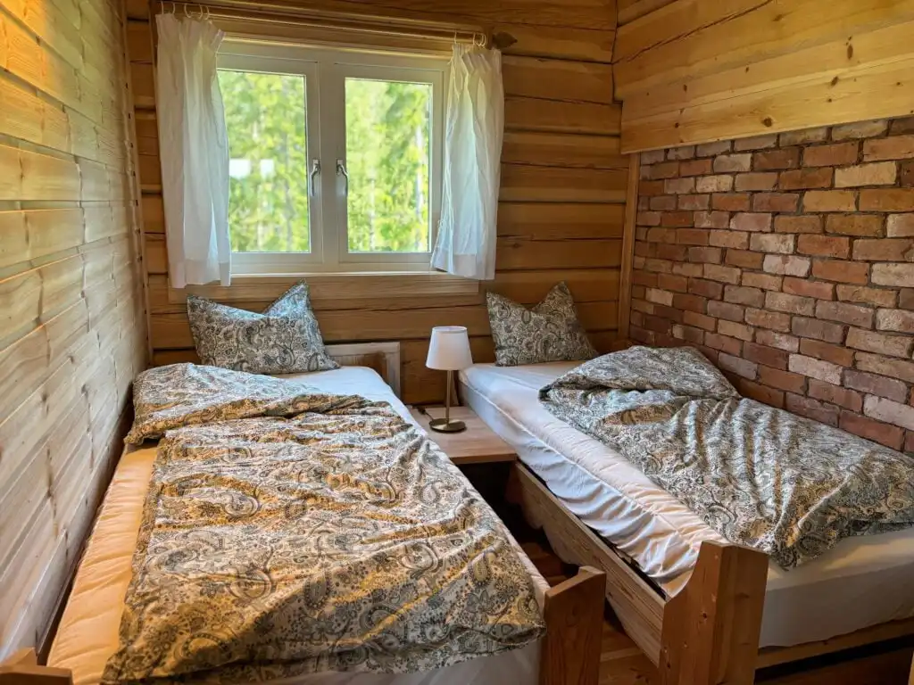 Schlafzimmer mit Natursteinwand in der Blockhütte Ratzeputz in Skillingfors – Ferienhaus in Värmland