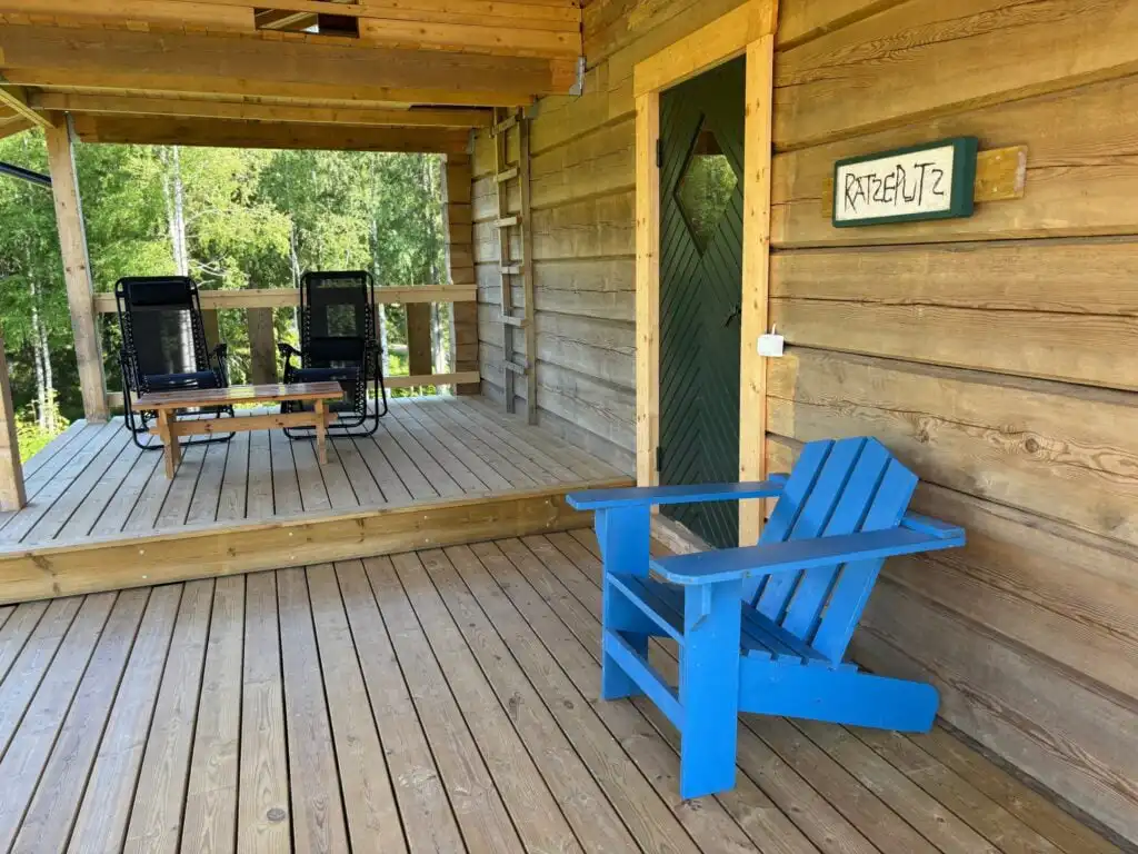 Holzterrasse der Blockhütte Ratzeputz in Skillingfors – Ferienhaus mit Seeblick in Värmland