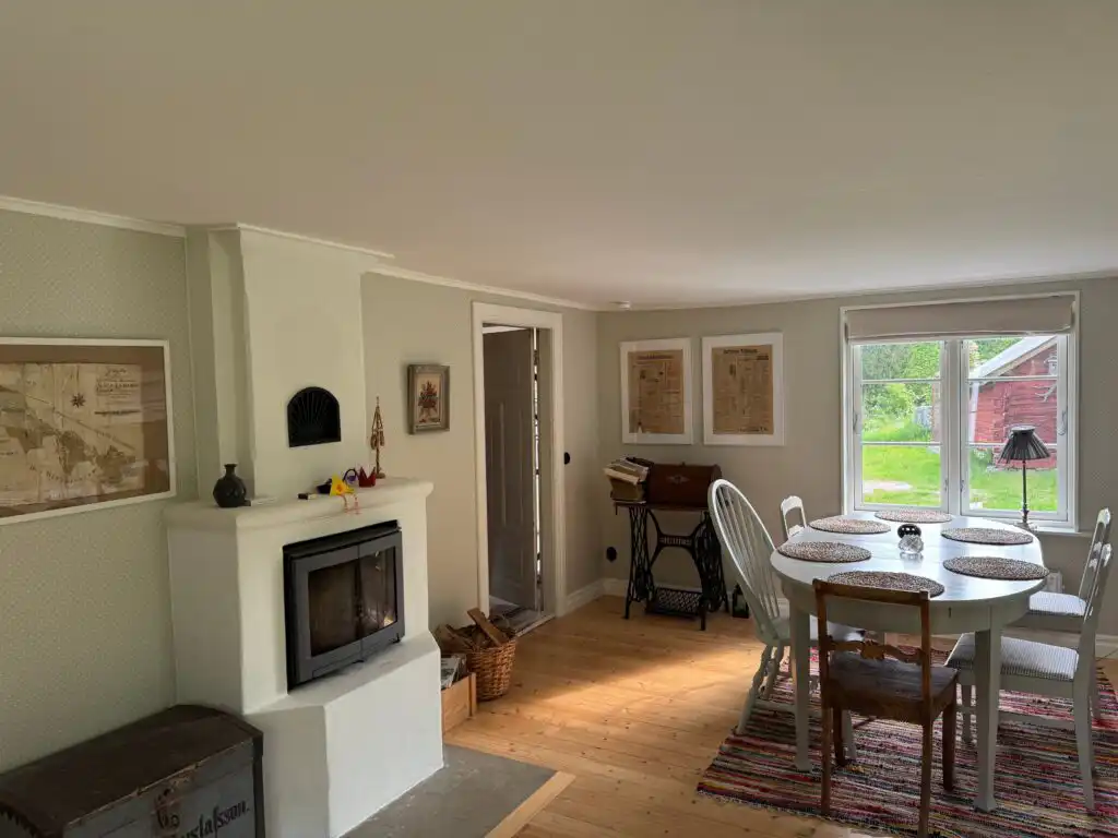 Wohnzimmer mit Kaminofen im Ferienhaus Hus Hällemåla – gemütlicher Aufenthaltsraum im Schwedenhaus