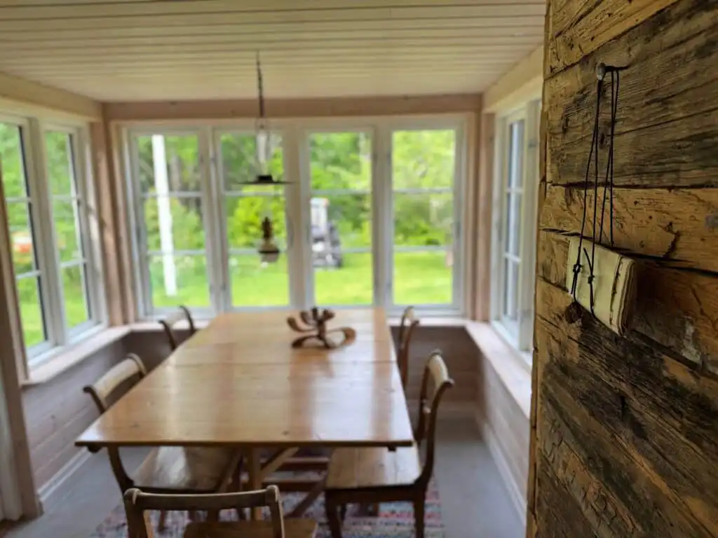Essbereich im Ferienhaus Hus Hällemåla – großer Esstisch mit Blick in die Natur