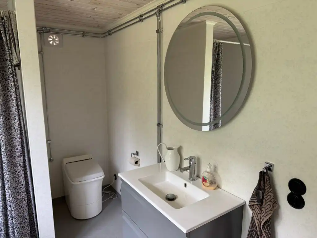 Badezimmer im Ferienhaus Hus Hällemåla – Badezimmer mit Waschbecken und Spiegel