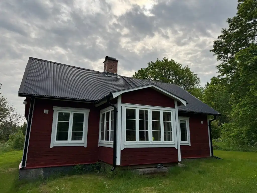 Hauptansicht vom Ferienhaus Hus Hällemåla mit Veranda – Ferienhaus mitten im Wald in Småland