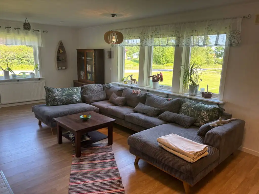 Helles Wohnzimmer mit großer Sofaecke im Ferienhaus Havsörn in Kalv – Natururlaub in Schweden