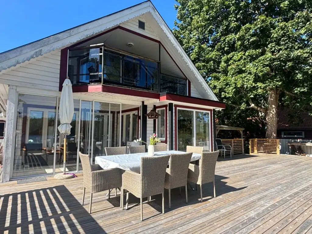 Außenansicht der Villa Seeblick mit großer Terrasse – Ferienhaus mitten im Wald am See