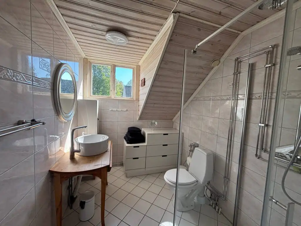 Badezimmer mit Holzoptik – Ferienhaus direkt am See in ruhiger Waldlage