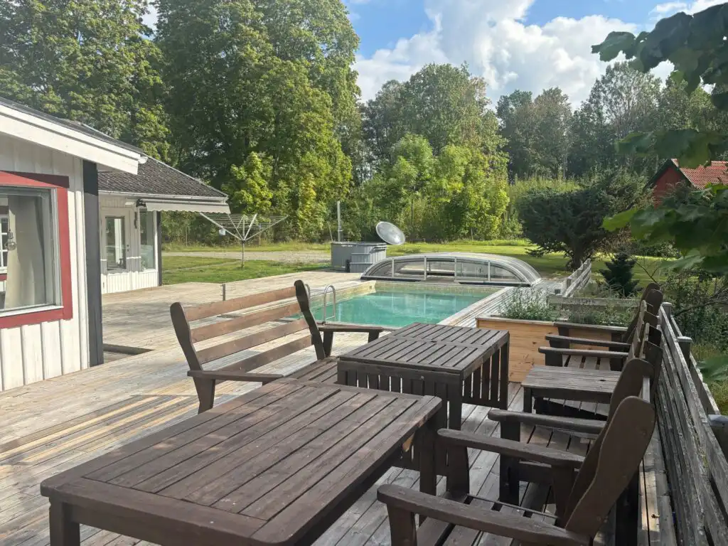 Große Terrasse mit Sitzmöbeln im Garten der Villa Waldsee – Ferienhaus im Wald in Vissefjärda