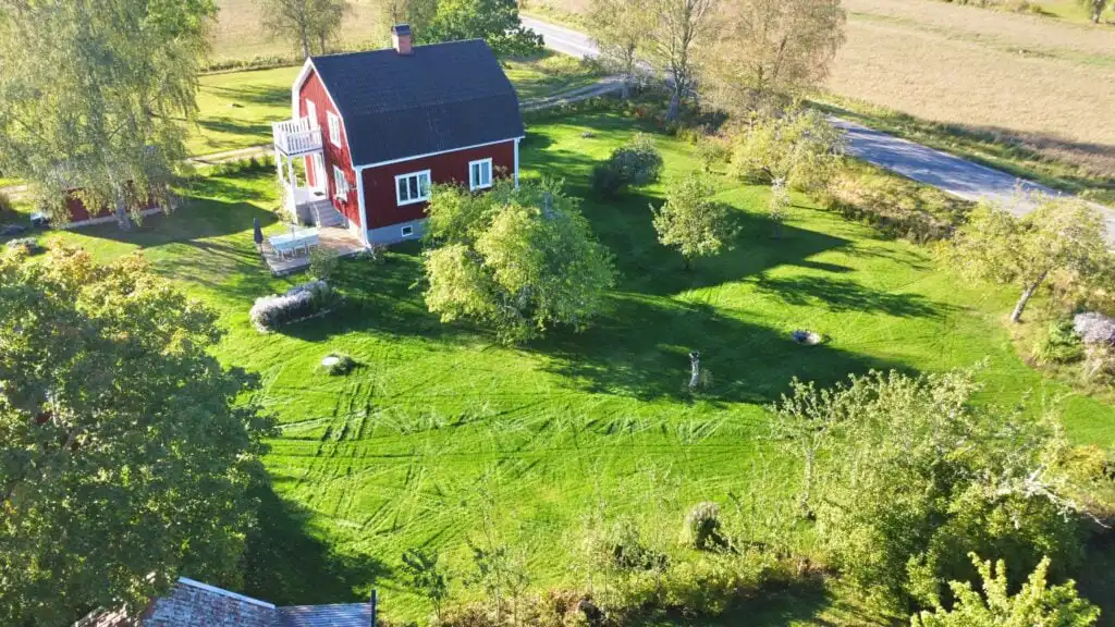 Vogelperspektive auf das Ferienhaus Hus Brobacka in Schweden – klassisches rotes Schwedenhaus in ländlicher Umgebung