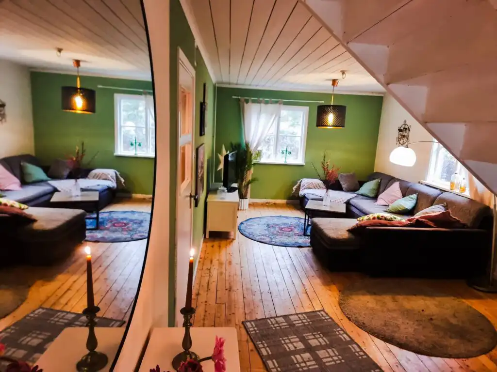 Wohnzimmer der Villa Clara mit Sofaecke und Blick ins Grüne – Ferienhaus auf Naturgrundstück nahe Blankaholm