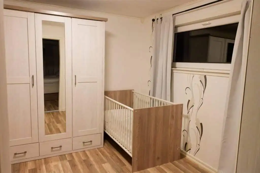 Schlafzimmer mit Babybett im Hus Lönnbacka in Småland – familienfreundliches Ferienhaus in Schweden