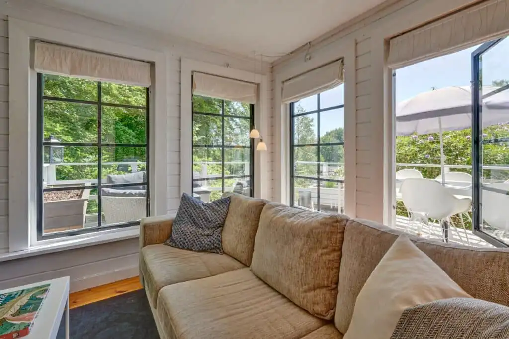 Wohnzimmer mit großen Fenstern im Ferienhaus Peaceful Getaway – Blick ins Grüne
