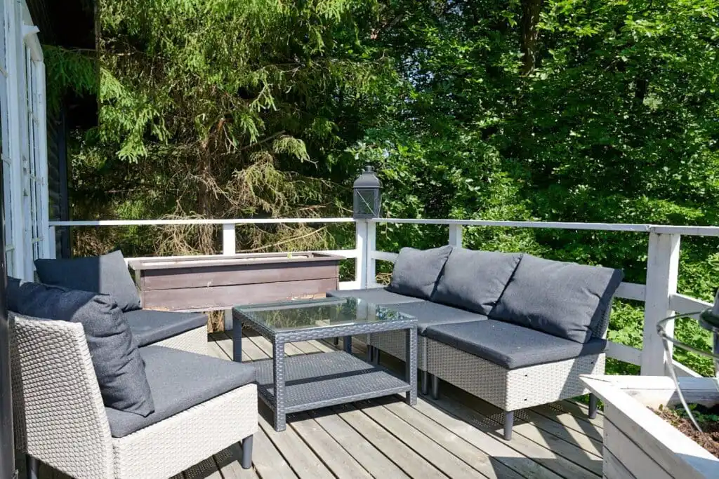 Terrasse mit Lounge-Möbeln am Ferienhaus Peaceful Getaway – Außenbereich mit Blick in die Natur