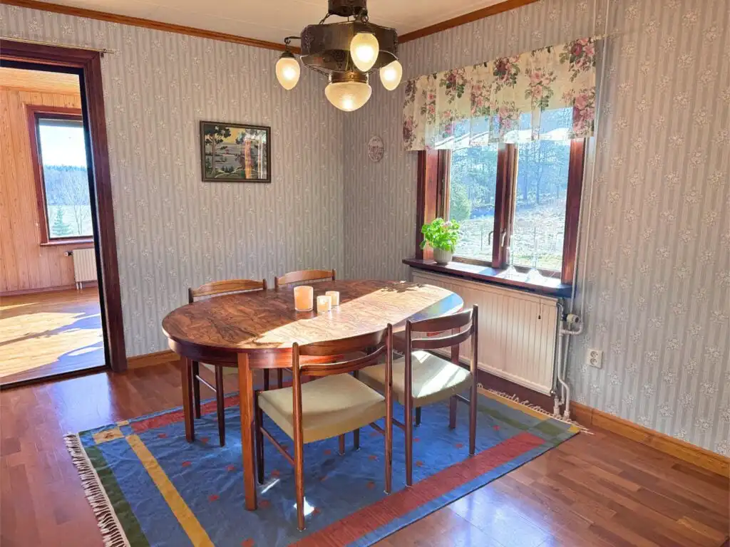 Essplatz im Ferienhaus Stora Hultet in Småland nahe Vimmerby mit Holztisch und Fenstern