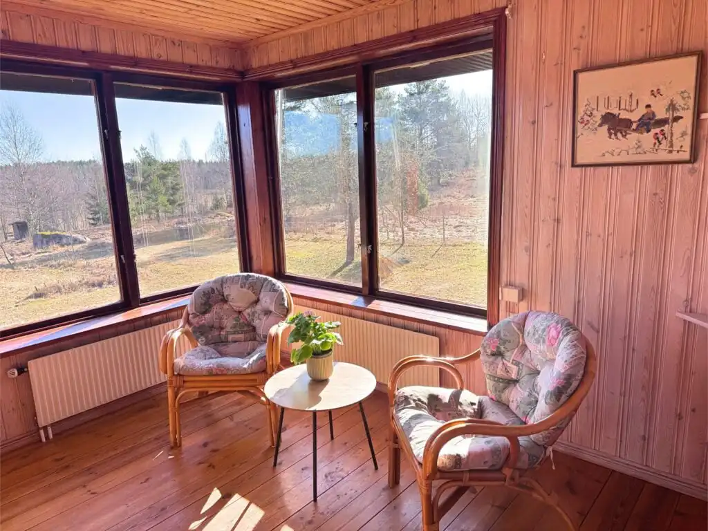 Heller Wintergarten im Ferienhaus Stora Hultet in Småland mit Blick in die Natur