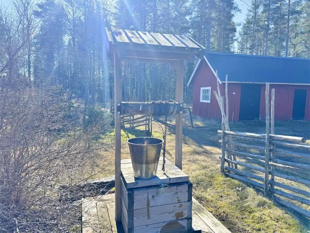Außenbereich mit Holzgebäuden und Zaun am Ferienhaus Stora Hultet in Småland nahe Vimmerby