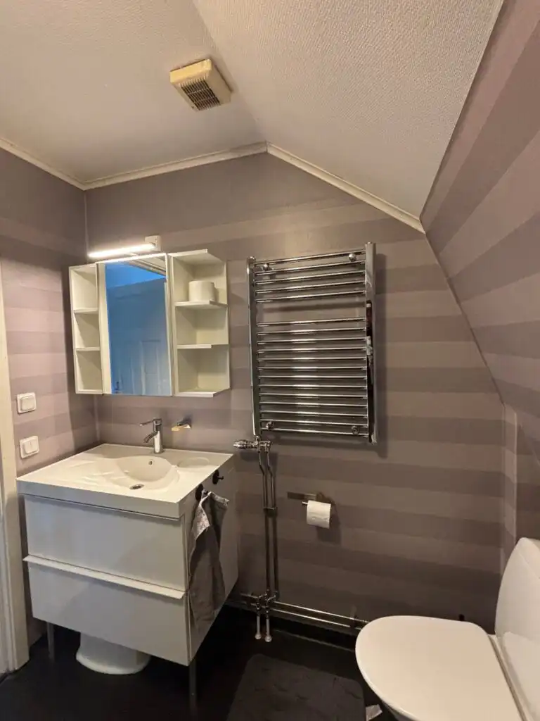 Helles Badezimmer im Ferienhaus Ryd mit Waschbecken und Spiegel