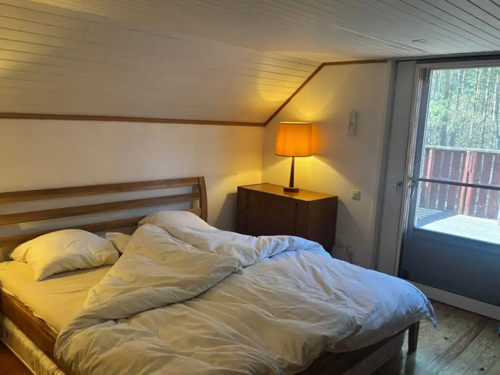 Schlafzimmer mit Doppelbett und Fenster im Ferienhaus in Småland
