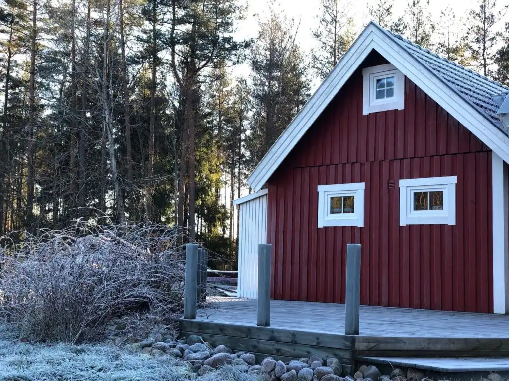 Ferienhaus im Winter mit Schnee im Wald in Südschweden