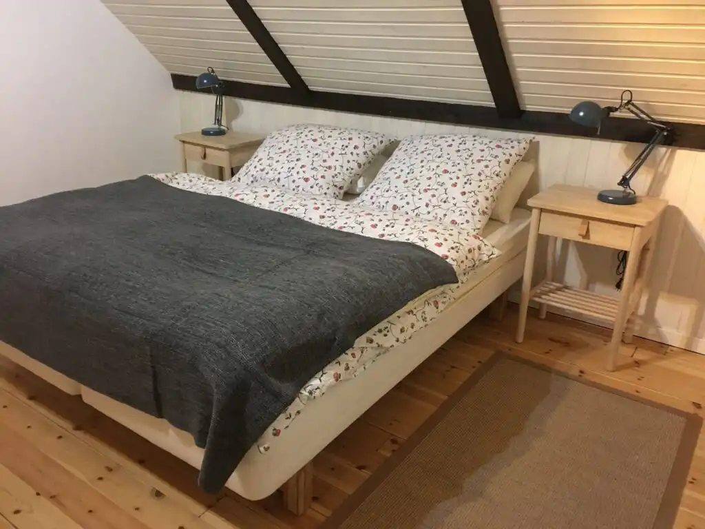 Schlafzimmer mit Doppelbett und Holzbalken im Ferienhaus Villa Yasjö