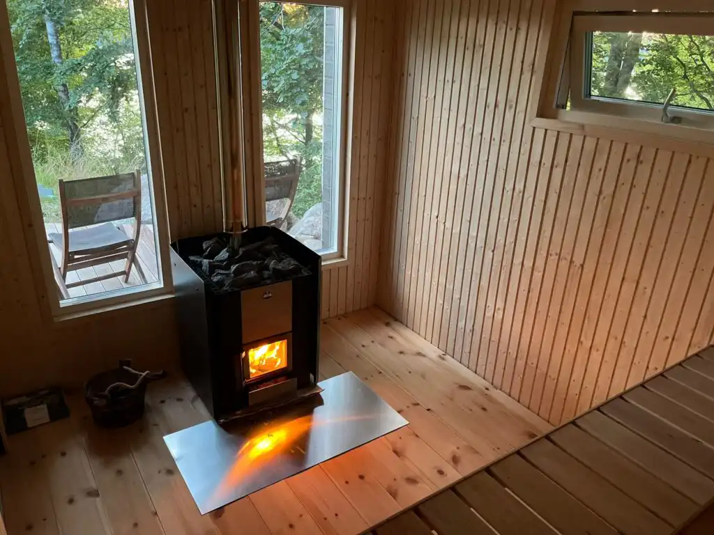 Saunaraum mit Holzofen im Saunahaus am Ferienhaus in Schweden