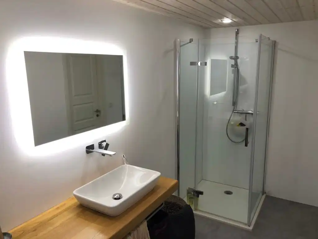 Badezimmer mit Spiegel und Dusche im Ferienhaus Villa Yasjö