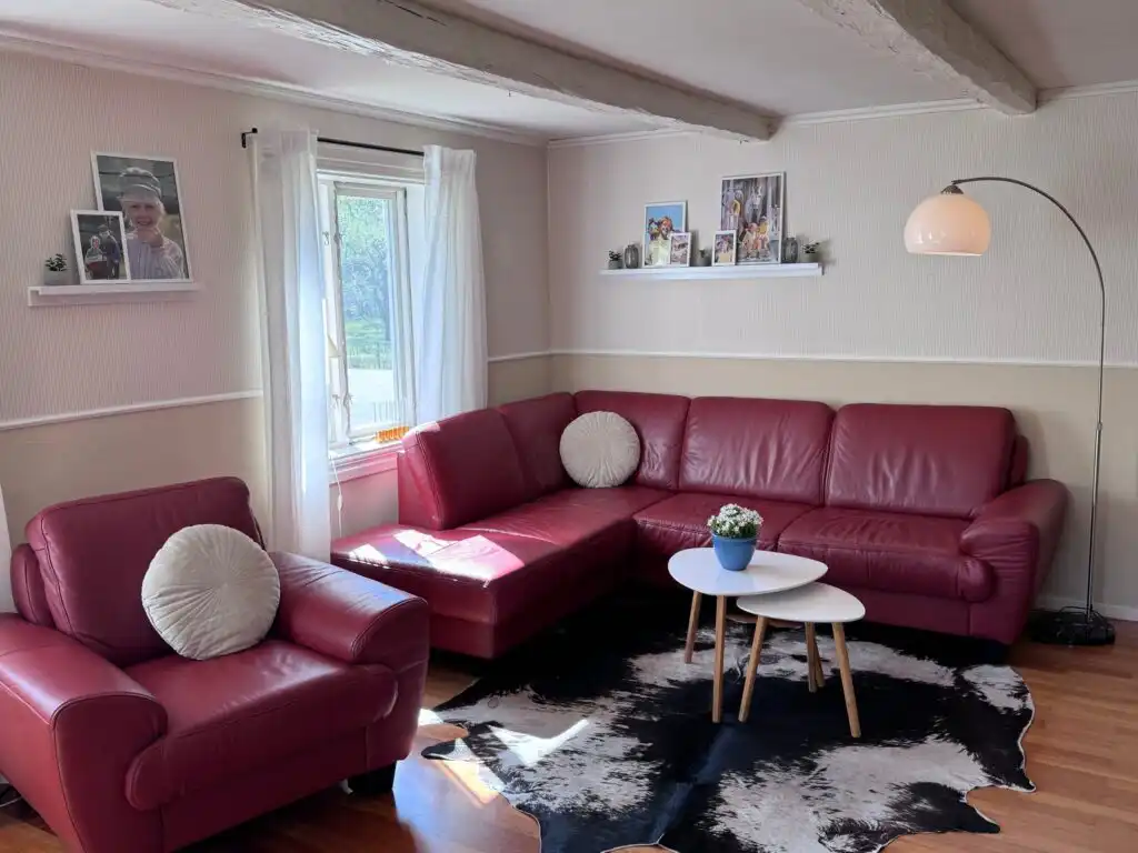 Wohnzimmer mit rotem Sofa und gemütlicher Einrichtung