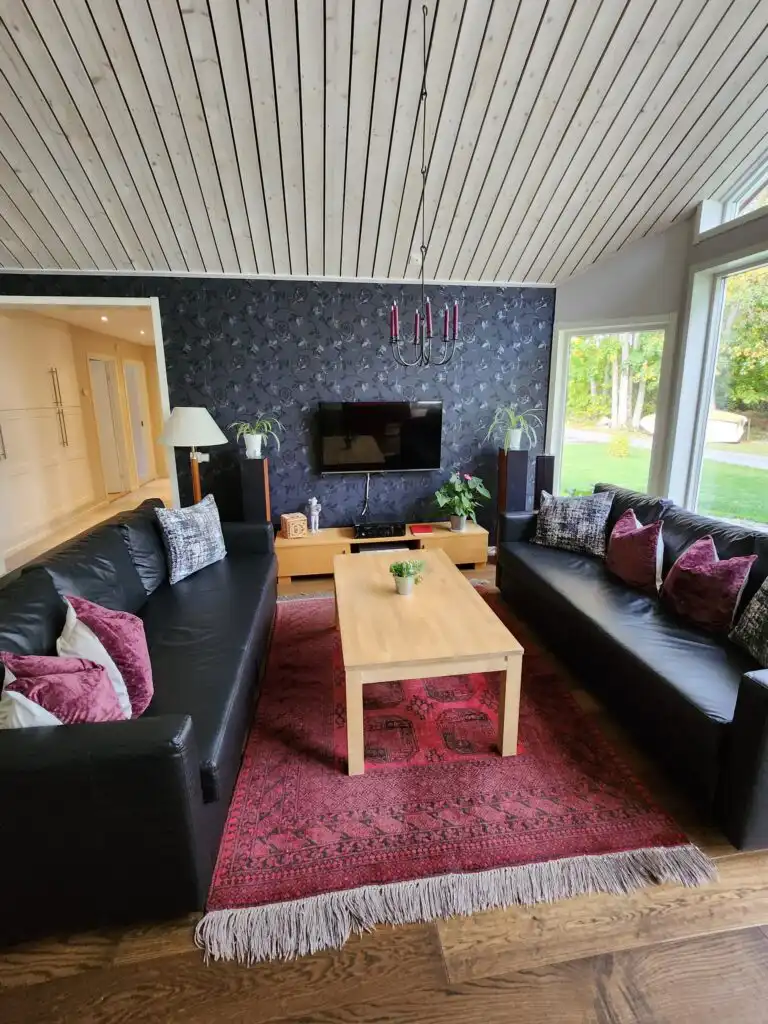 Wohnbereich mit Sofa und Seeblick im Ferienhaus Skogshem in Småland