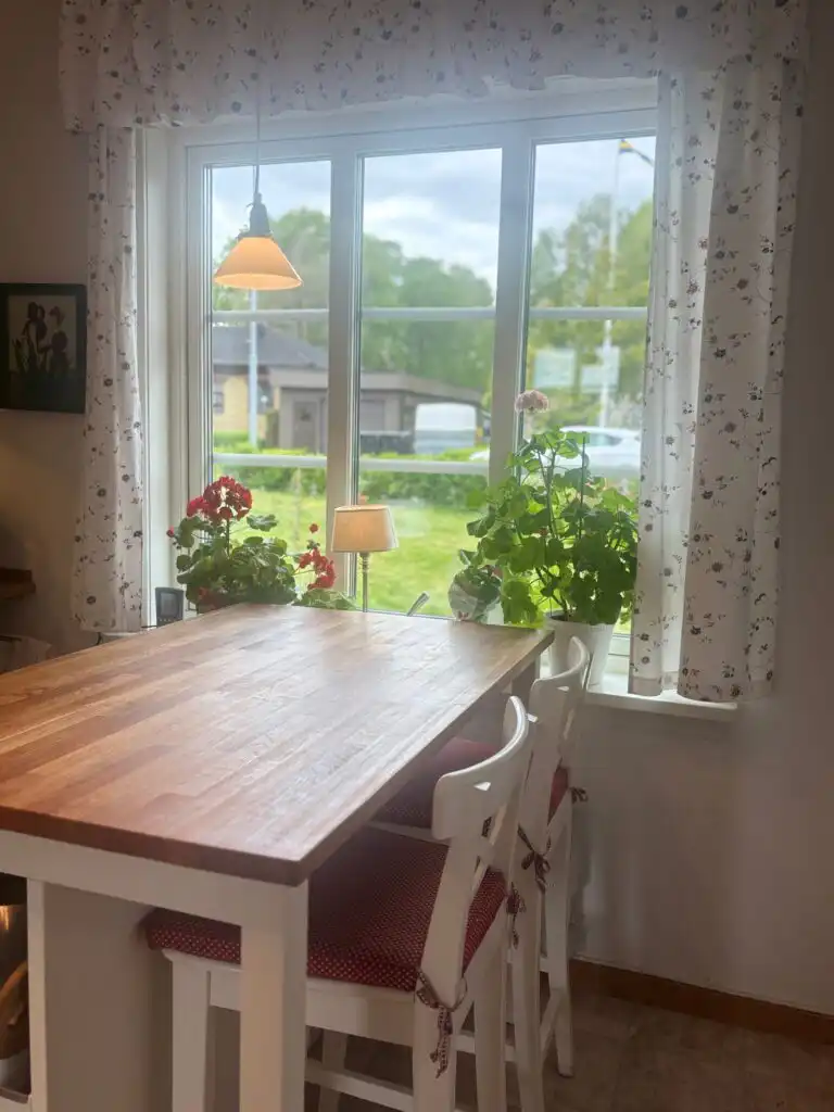 Heller Essbereich mit Blick in den Garten des Ferienhauses