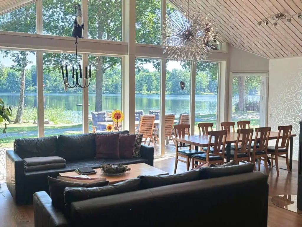Wohnzimmer mit großen Fensterfronten und Seeblick in Skogshem