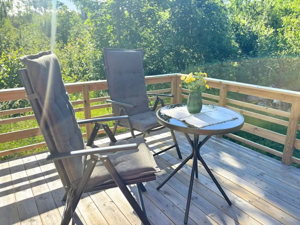 Sonnige Holzterrasse der Älg Stuga in Småland