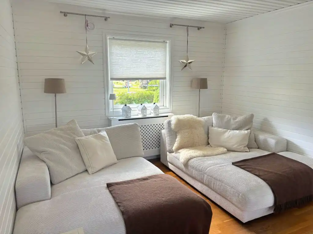 Gemütliches Wohnzimmer mit Sofa und Blick ins Grüne in Villa Saleboda