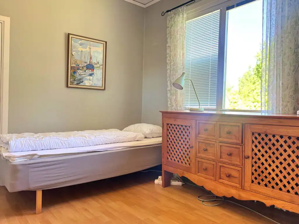 Helles Schlafzimmer mit Einzelbett und Kommode im Connys Hus