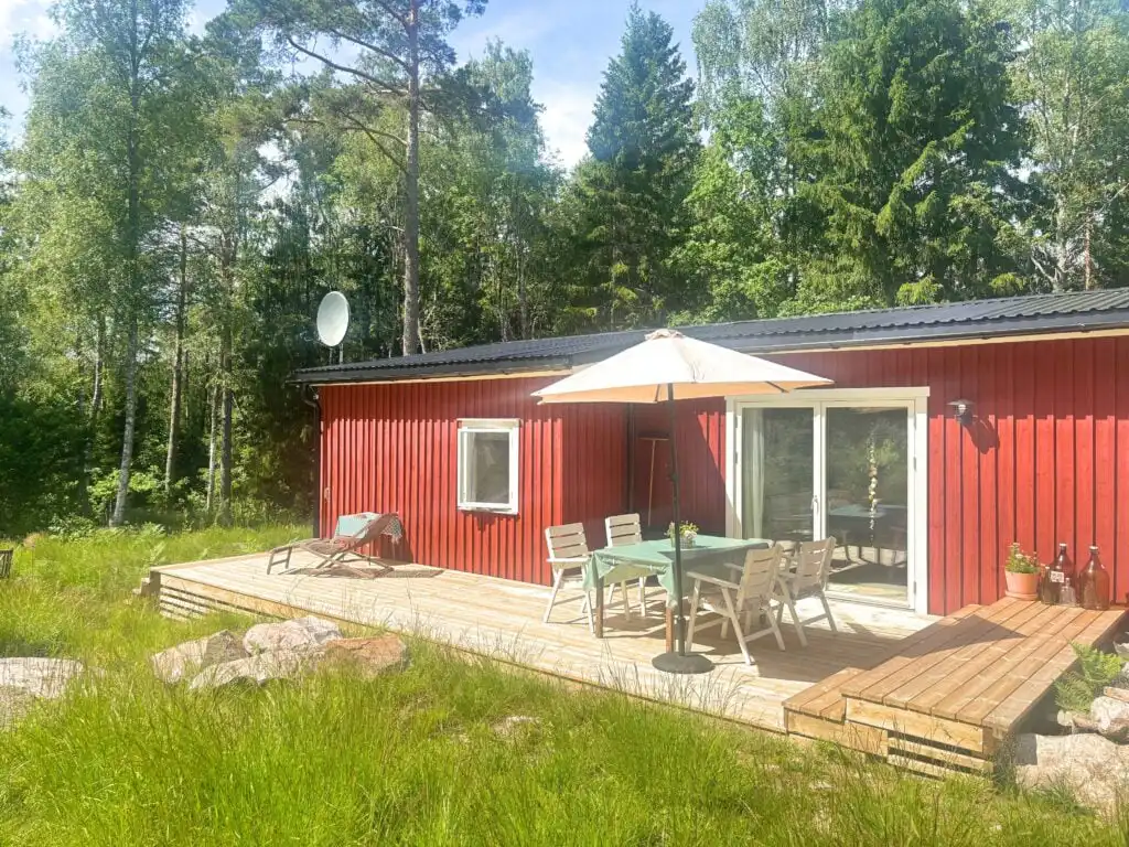 Außenansicht der Stuga Haget mit Terrasse und Naturgrundstück