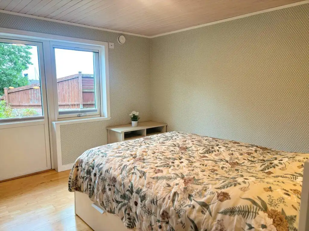 Helles Schlafzimmer mit Doppelbett und Gartenblick im Blå Havet