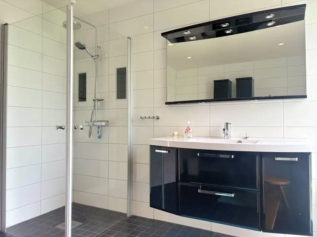 Badezimmer mit Dusche und moderner Ausstattung im Linnéagården