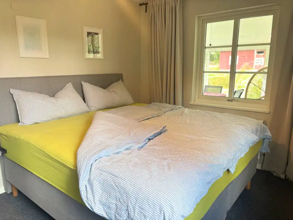 Gemütliches Doppelbett im Schlafzimmer von Linnéagården