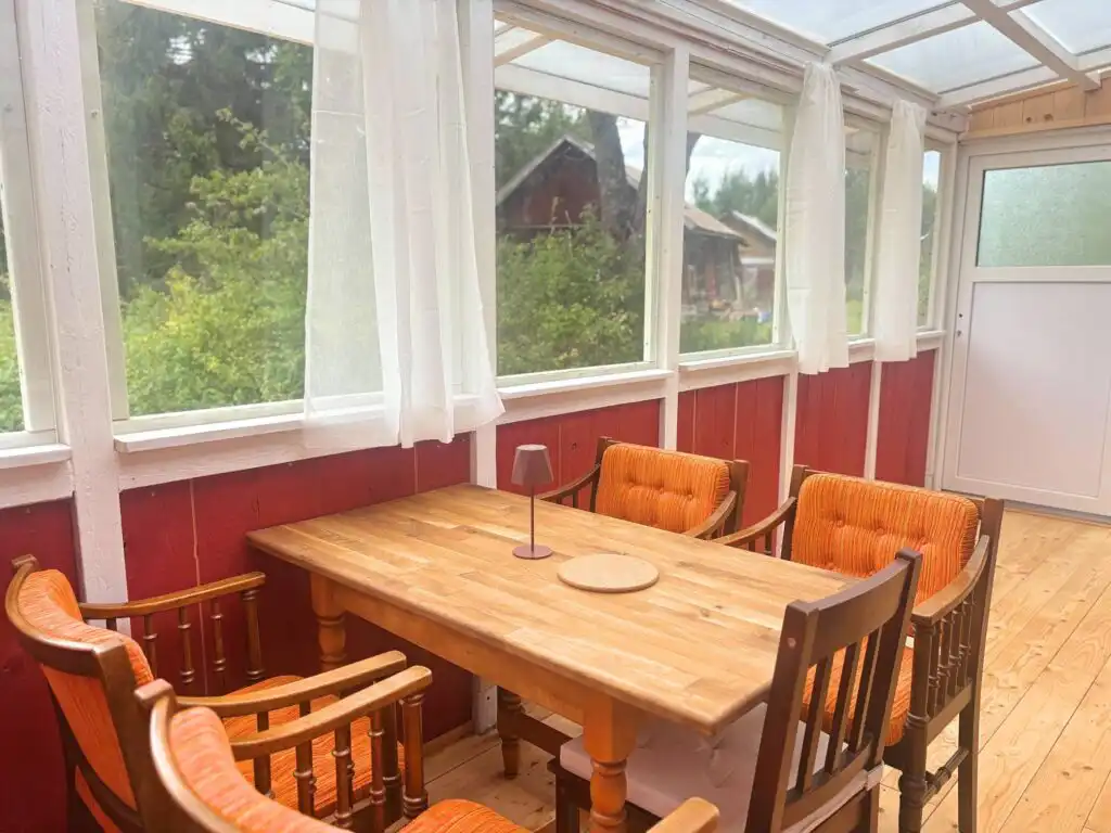 Heller Wintergarten mit großem Esstisch in der Villa Pelle