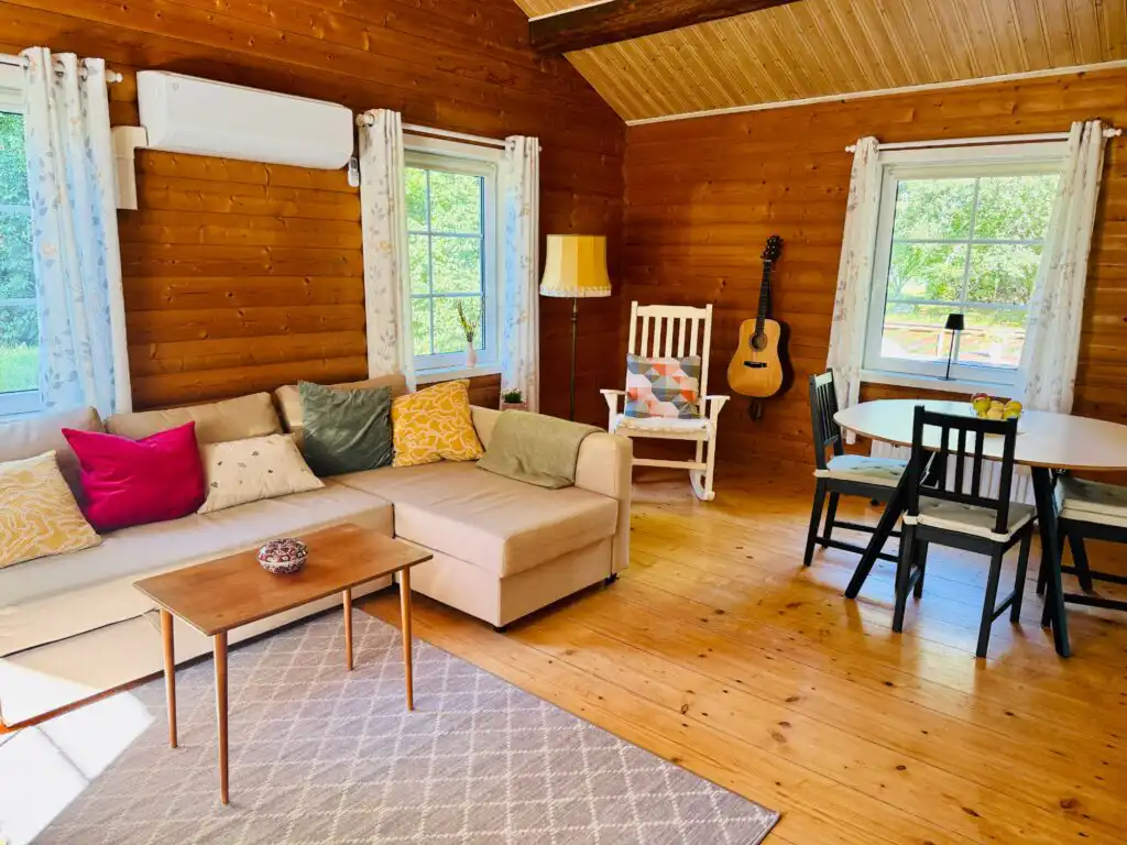 Heller Wohnbereich mit Sofa und Essplatz im Ferienhaus Sommerlycka